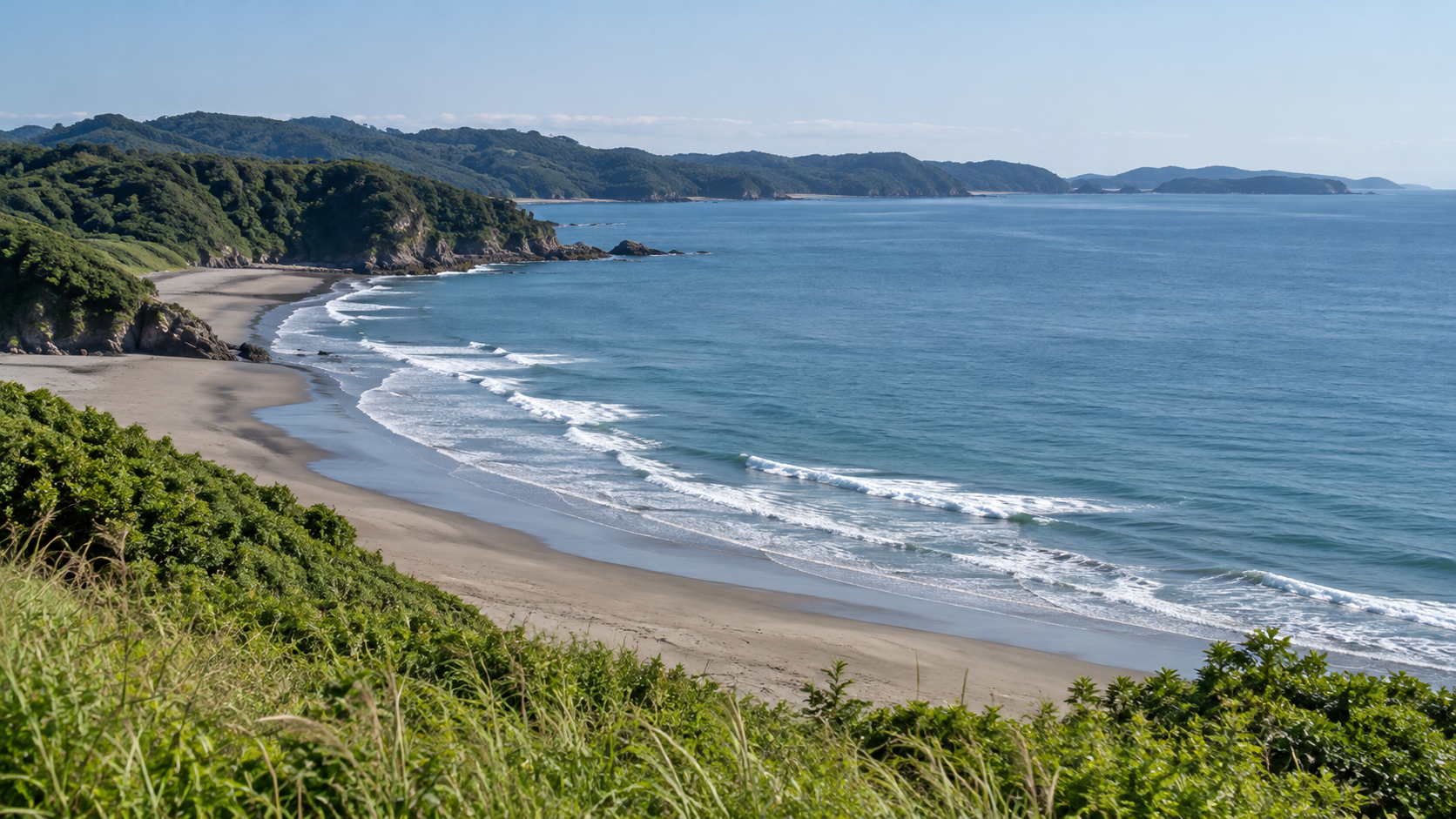 高い場所から砂浜と普通の波、緑の岬を眺める現代の海岸イメージ